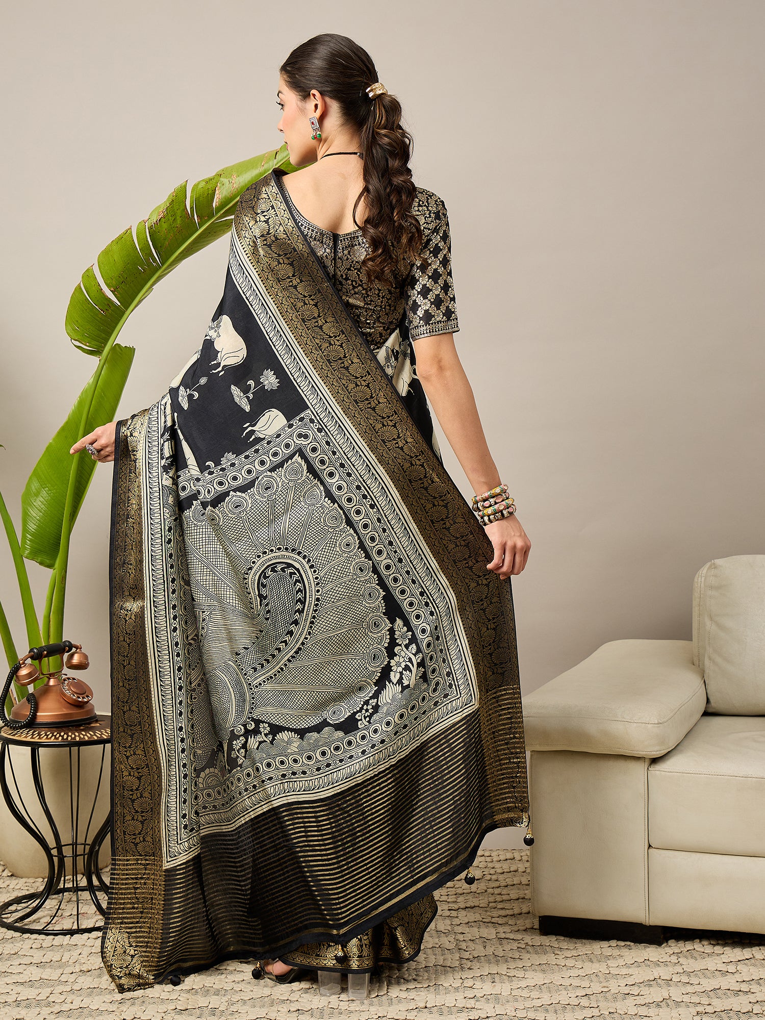 ADHIRA-Elegant black saree featuring intricate traditional mythological and folk art inspired prints