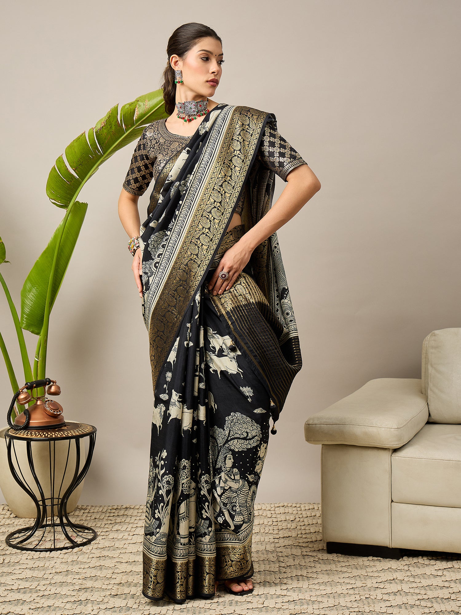 ADHIRA-Elegant black saree featuring intricate traditional mythological and folk art inspired prints