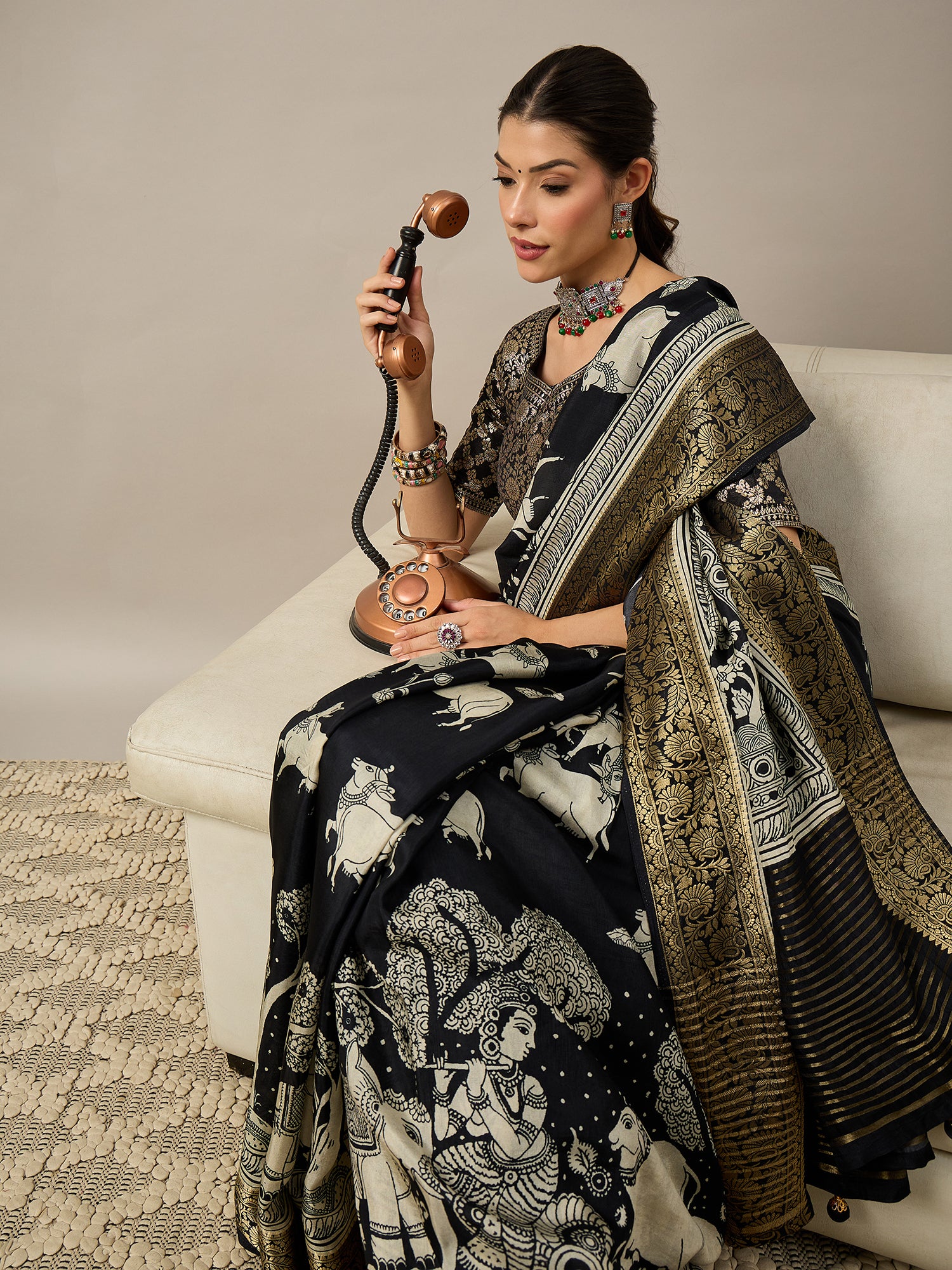 ADHIRA-Elegant black saree featuring intricate traditional mythological and folk art inspired prints