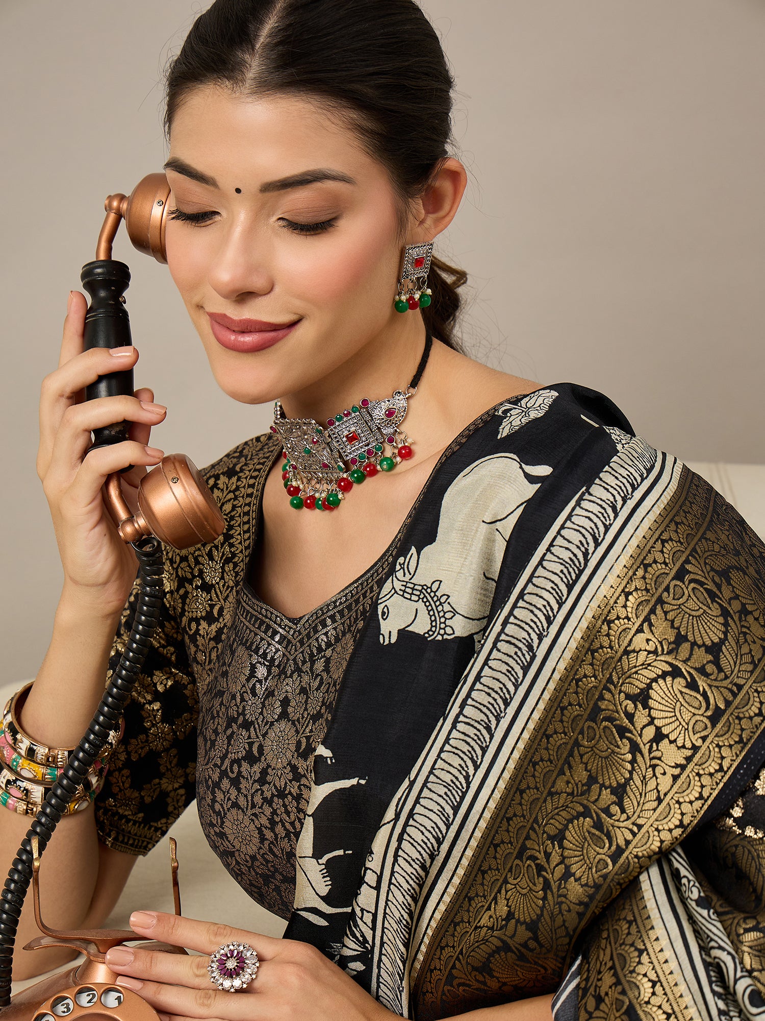 ADHIRA-Elegant black saree featuring intricate traditional mythological and folk art inspired prints